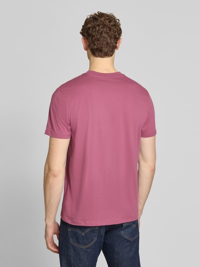 Männermodel trägt T-Shirt mit Logo-Patch und Rundhalsausschnitt von GAP in Rosa, reine Baumwolle, Straight Fit, Ganzkörperansicht Rückansicht.