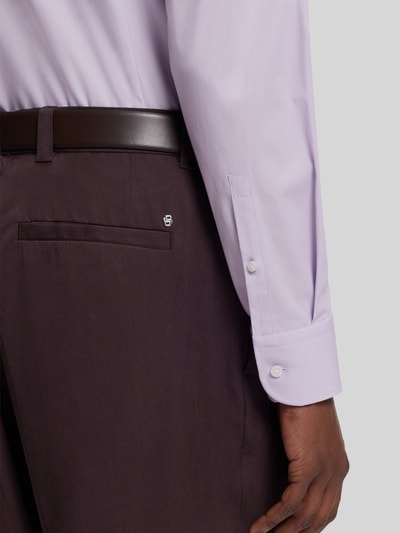 Männermodel trägt Slim Fit Businesshemd aus Baumwoll-Mix Modell 'H-HANK-KENT' von BOSS, helles Lila, glatte Textur, Detailaufnahme Arm.