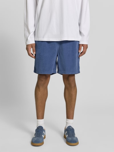 Männermodel trägt Shorts mit elastischem Bund Modell 'PADOW' von American Vintage in Blau, reine Baumwolle, Loose Fit, Ganzkörperansicht von vorne.