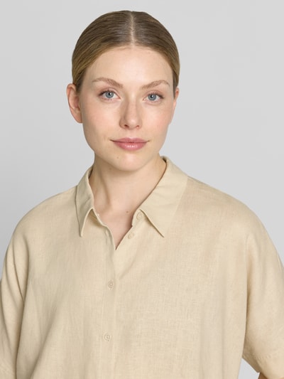 Frauenmodel trägt Leinenbluse mit Hemdblusenkragen von Comma, Leinen-Mix mit Lyocell-Anteil, Knopfleiste, Farbe Beige, Nahaufnahme Oberkörper.