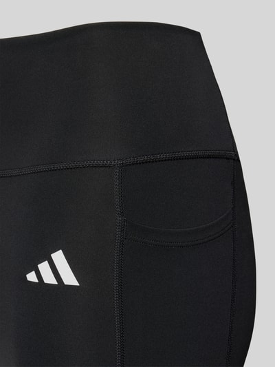 Produktfoto, schwarze Sport-Leggings mit Logo-Print Modell 'OPT ESS ST 1/1' von adidas, glatte Textur, Kontext: Damen Sport-Leggings von adidas Training