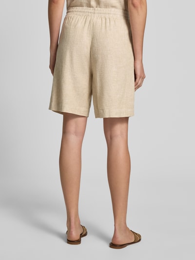 Frauenmodel trägt Leinenshorts mit elastischem Bund Modell 'Lava' von FREE/QUENT, Naturton, Leinen-Mix mit Viskose-Anteil, Loose-Fit, französische Eingrifftaschen, elastischer Bund mit Kordelzug, Textur leicht strukturiert, Bundweite 39 cm, Innenbeinlänge 50 cm, Ganzkörperansicht Rückansicht.