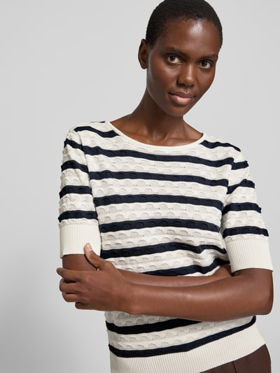 Frauenmodel trägt Strickshirt mit Rundhalsausschnitt Modell 'Dodo' von FREE/QUENT in Schwarz-Weiß mit geraden, gerippten Abschlüssen, reine Baumwolle, Nahaufnahme Oberkörper.