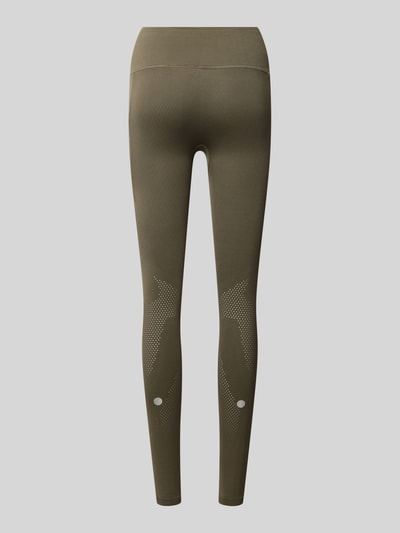 Frauenmodel trägt Slim Fit Leggings mit Logo-Print von ASICS in Olivgrün mit elastischem Bund und Struktur-Partien, Ganzkörperansicht Rückansicht.