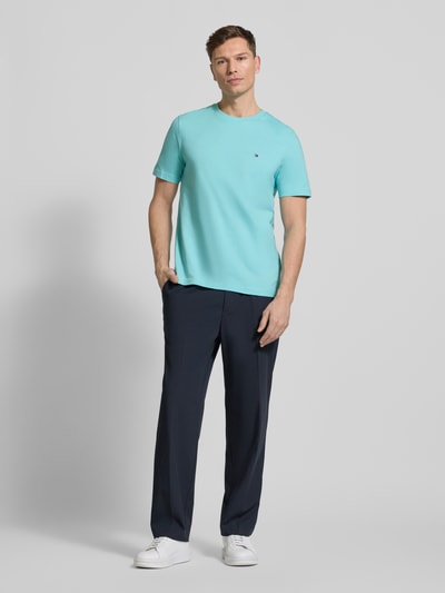 Männermodel trägt Regular Fit T-Shirt aus reiner Baumwolle von Tommy Hilfiger, Optik: Unifarben, Logo-Stitching, Jersey, Ganzkörperansicht von vorne.