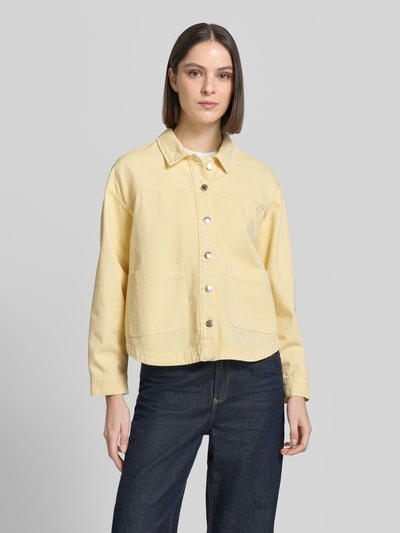 Frauenmodel trägt Regular Fit Overshirt aus reiner Baumwolle Modell 'JAMIE' von Vero Moda in Denim-Optik, Twill, Langarm, Knopfleiste, Seitentasche, Rückenpasse, Ganzkörperansicht von vorne.