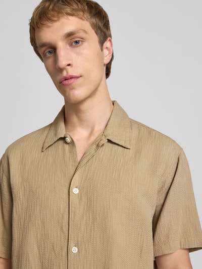 Männermodel trägt Regular Fit Freizeithemd mit Strukturmuster Modell 'MONTAUK' von Jack & Jones, beiger Ton, Nahaufnahme Oberkörper. Baumwolle, Kentkragen, Knopfleiste, 28 cm Ärmellänge.