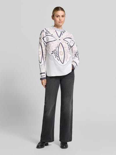 Vrouwenmodel draagt Regular Fit Bluse aus Seiden-Mix van HERZENS met bloemenprint, opstaande kraag, zijdemix, regular fit, lang met lange mouwen, ruglengte maat 36: 71 cm, mouwlengte maat 36: 66 cm, wit en beige tinten, helemaal van voren