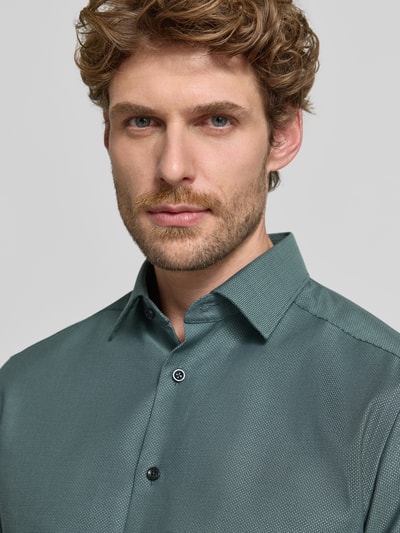 Männermodel trägt Modern Fit Businesshemd mit extra langem Arm von OLYMP in grünlicher Farbe, feines Muster, Nahaufnahme Oberkörper, Herren Businesshemd von OLYMP