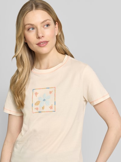 Kobiece modelka nosi damski t-shirt z motywem i okrągłym dekoltem od Jake*s Casual z czystej bawełny, krój regular fit, długość tyłu w rozmiarze S: 59 cm, jasny kolor, prosty fason, faktura gładka, motyw na przodzie. Zbliżenie na górną część ciała.