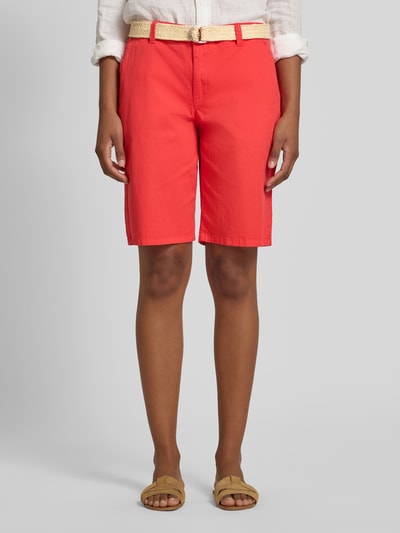 Frauenmodel trägt Bermudas mit Gürtel Modell 'ROVENA' von Soyaconcept aus Baumwoll-Elasthan-Mix in Regular-Fit, Bundweite 41 cm, Innenbeinlänge 26 cm, leuchtender Rotton, glatte Struktur, Ganzkörperansicht von vorne.