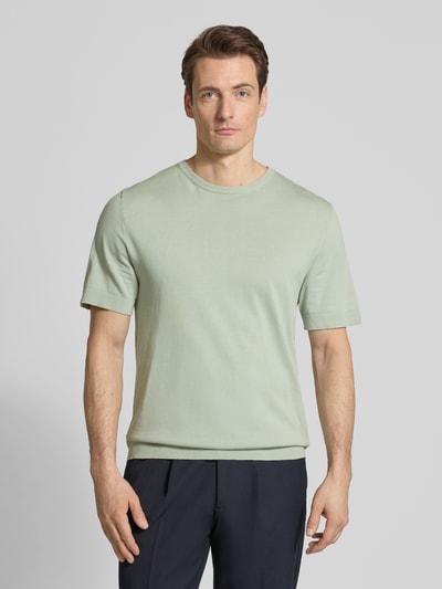 Männermodel trägt Regular Fit Strick-Shirt aus Bio-Baumwolle Modell 'TORINO' von Selected Homme, look: effen, fijngebreid, ronde hals, korte mouw, ganzkörperansicht von vorne