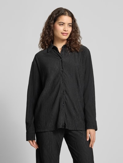 Frauenmodel trägt Relaxed Fit Bluse mit Strukturmuster von REVIEW in Schwarz mit Hemdblusenkragen, Knopfleiste, Material-Mix mit Stretch-Anteil, Ganzkörperansicht von vorne.