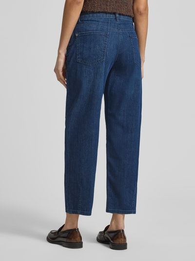 Frauenmodel trägt Barrel Fit Jeans mit Eingrifftaschen Modell 'BOBBIE' von MAC aus Baumwoll-Mix mit Stretch-Anteil, blaue Denimoptik, Ganzkörperansicht Rückansicht.