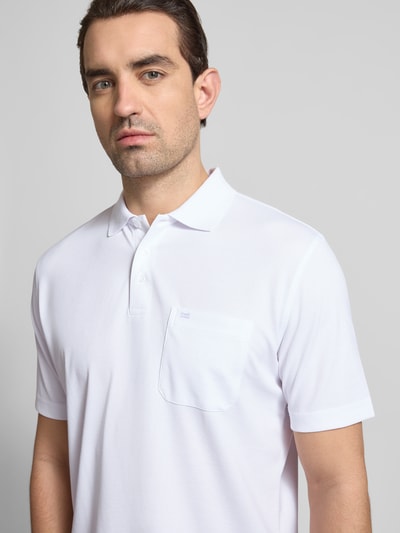 Männermodel trägt Regular Fit Poloshirt mit Brusttasche von Christian Berg Men, weiß, Polokragen, Knopfleiste, Baumwoll-Mix, Nahaufnahme Oberkörper.