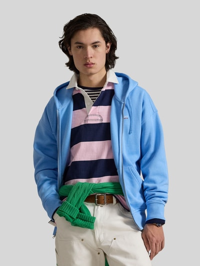 Männermodel trägt Relaxed Fit Sweatjacke aus Baumwoll-Mix von Polo Ralph Lauren in Hellblau mit Kapuze und Reißverschluss, Nahaufnahme Oberkörper.