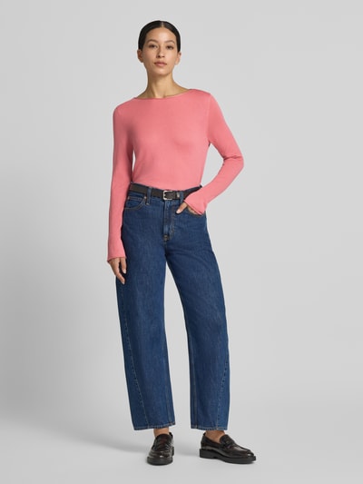 Frauenmodel trägt Regular Fit Pullover aus reiner Schurwolle von Marc O'Polo in Rosa, kombiniert mit blauen Jeans, Ganzkörperansicht von vorne, Damen Pullover von Marc O'Polo.