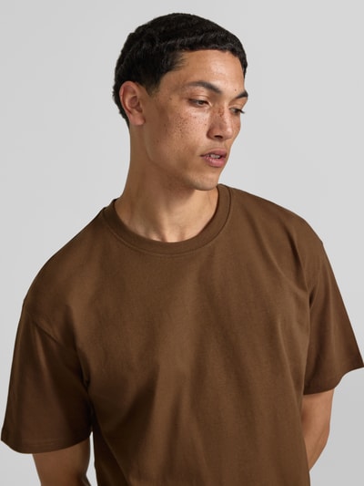 Męski model nosi Regular Fit T-Shirt mit Rundhalsausschnitt von Jack & Jones, bawełna, krój regular fit, okrągły dekolt, rękaw o dł. 1/2, długość tyłu w rozmiarze M: 70 cm, brązowy, gładka tekstura, Nahaufnahme górnej części ciała.