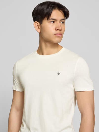 Männermodel trägt Basic Slim Fit T-Shirt mit Flock-Logo auf der Brust von REVIEW aus Baumwoll-Viskose-Mix, Nahaufnahme Oberkörper.