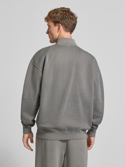 Męski model nosi Relaxed Fit Sweatshirt aus Baumwoll-Mix od PEGADOR, szary kolor, ozdobne szwy, wyhaftowane logo, długi rękaw, kołnierz zapinany, prążkowane wykończenia, mieszanka bawełny, Ganzkörperansicht Rückansicht.
