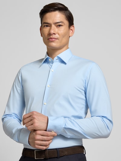 Männermodel trägt Slim Fit Businesshemd aus Baumwoll-Mix Modell 'H-HANK-KENT-C1-214' von BOSS in Hellblau, Nahaufnahme Oberkörper.