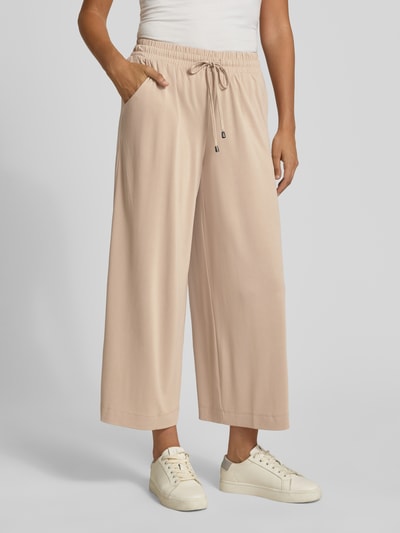 Vrouwenmodel draagt Straight Fit Stoffhose in verkürzter Passform van Christian Berg Woman, modalmix, elastische band met tunnelkoord, binnenbeenlengte 66 cm, bandwijdte 33 cm, verkort model, lichte beige kleur, gladde textuur, comfortbroekdesign, Ganzkörperansicht van voren.
