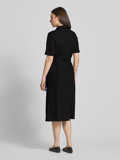 Modelka nosi czarne, jednokolorowe Freizeitkleid aus Viskose-Leinen-Mix Modell 'PIA' od Pieces, midi, z krótkim rękawem, widok z tyłu całej sylwetki.