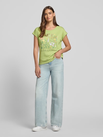 Frauenmodel trägt Damen T-Shirt mit Motiv-Print und Rundhalsausschnitt von Christian Berg Woman, Baumwoll-Viskose-Mix, Regular-Fit, grün, florale Elemente, glatte Oberfläche, Rückenlänge bei Größe S 56 cm, Ganzkörperansicht von vorne.