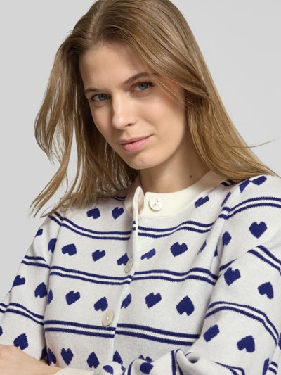 Frauenmodel trägt Regular Fit Cardigan mit Allover-Motiv-Stitching Modell 'Brielle' von ICHI in Strick-Optik, Nahaufnahme Oberkörper.