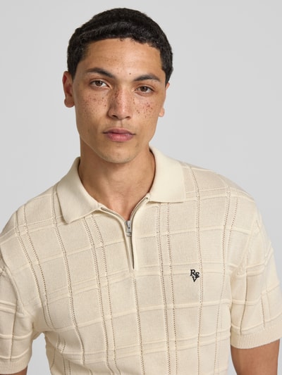 Männermodel trägt Modern Fit Poloshirt mit Logo-Stitching von REVIEW in Beige mit Strukturmuster aus Reine Baumwolle, Nahaufnahme Oberkörper.
