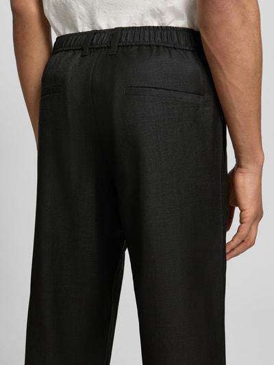 Männermodel trägt Hose mit Eingrifftaschen Modell 'NOAH' von Samsøe Samsøe aus Reine Baumwolle, Straight Fit, Ganzkörperansicht Rückansicht