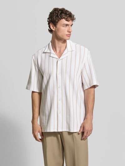 Männermodel trägt Relaxed Fit Kurzarmhemd aus Baumwoll-Mix von BOSS mit Allover-Muster, Reverskragen, beige-weiße Streifen, Ganzkörperansicht von vorne.