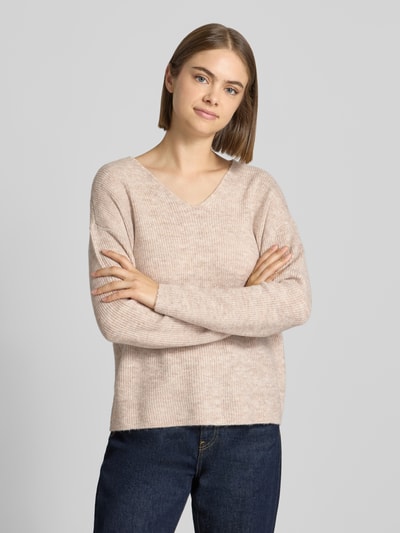 Frauenmodel trägt Regular Fit Pullover mit V-Ausschnitt Modell 'CAMILLA' von ONLY in Beige, grobe Strickstruktur, Damen Pullover, Nahaufnahme Oberkörper.