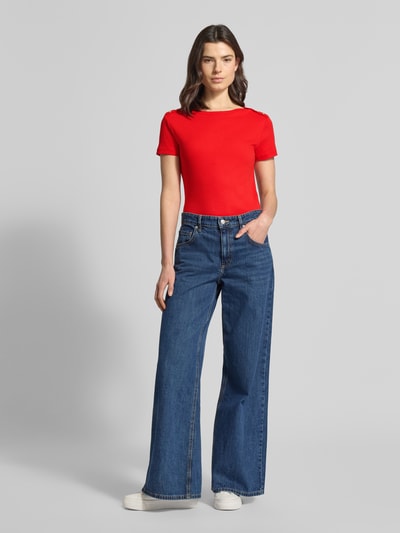 Frauenmodel trägt Slim Fit T-Shirt aus reiner Baumwolle von Tommy Hilfiger in Optik: Unifarben, Logo-Detail, Zierknöpfe, U-Boot-Ausschnitt, Ärmelform: Kurzarm, Ärmelabschluss: Gerade, Materialverarbeitung: Reine Baumwolle, Ganzkörperansicht von vorne.