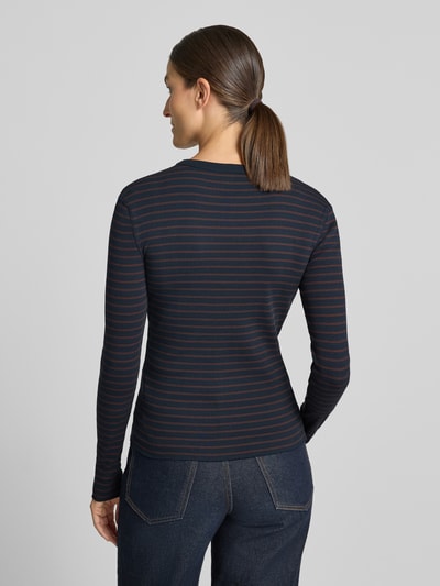 Frauenmodel trägt Slim Fit Longsleeve aus reiner Baumwolle Modell 'NURIT' von DRYKORN, dunkle Streifen, Ganzkörperansicht Rückansicht.