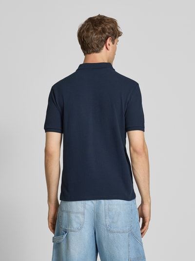 Mannenmodel draagt Modern Fit Poloshirt met logo-Stitching van REVIEW in donkerblauw katoenmix, polokraag, korte knoopsluiting, ruglengte bij maat M 65 cm, geheellichaamsbeeld achteraanzicht.