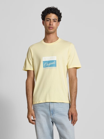 Männermodel trägt T-Shirt mit Statement-Print Modell 'RHYERES' von Jack & Jones in Gelb, Regular Fit, reine gewachste Baumwolle, Ganzkörperansicht von vorne.