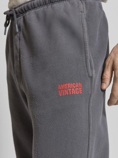 Männermodel trägt Sweatpants aus Baumwolle Modell 'PLIZZY' von American Vintage, gerader Schnitt, Label-Detail, Nahaufnahme Oberschenkel.