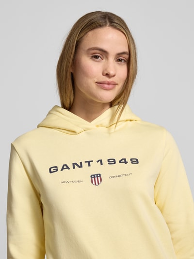 Frauenmodel trägt Regular Fit Hoodie mit Label-Print von Gant in Gelb aus Baumwoll-Mix, Label-Print vorn, Nahaufnahme Oberkörper.