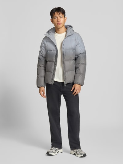 Männermodel trägt silbergraue Regular Fit Daunenjacke mit Zweiwege-Reißverschluss Modell 'BERKELY' von Calvin Klein Jeans, Ganzkörperansicht von vorne.