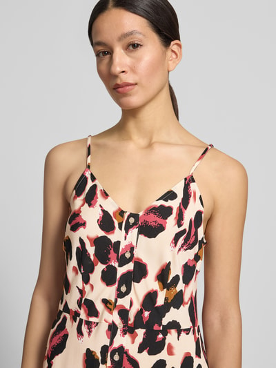 Frauenmodel trägt Maxikleid aus Viskose mit Knopfleiste Modell 'SAVANNA' von YAS im Allover-Look, V-Ausschnitt und Spaghettiträger, Nahaufnahme Oberkörper. Rückenlänge bei Größe 36: 119 cm, Brustweite bei Größe 36: 41 cm. Farben: Beige, Schwarz, Rot, Details mit sanfter Textur.