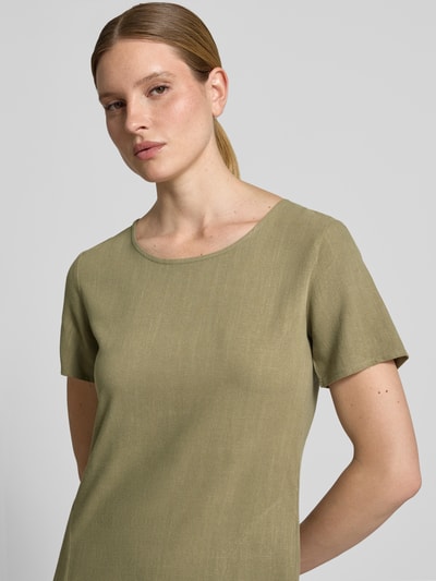 Frauenmodel trägt Relaxed Fit Kleid aus Viskose-Mix Modell 'Tara' von ZABAIONE mit Rundhalsausschnitt, Kurzärmelig, Olivgrün, Nahaufnahme Oberkörper. Rückenlänge bei Größe S: 96 cm, Brustweite bei Größe S: 49 cm, Ärmellänge bei Größe S: 21 cm. Textur aus Leinen-Viskose-Anteil.