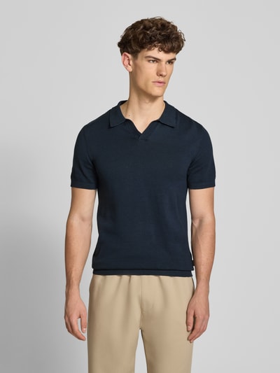 Männermodel trägt Regular Fit Poloshirt in Strick-Optik Modell 'Bray' von Blend, Reine Baumwolle, dunkelblau, Kurzärmelig, Ganzkörperansicht von vorne.