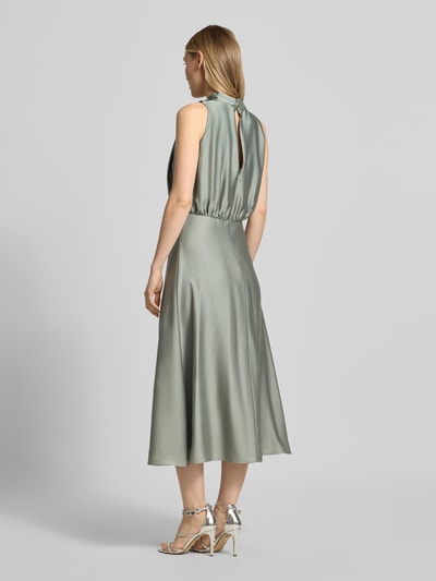 Frauenmodel trägt Cocktailkleid mit Stehkragen von Swing in taillierter Passform, Midilänge, seidige Textur, Ganzkörperansicht Rückansicht.