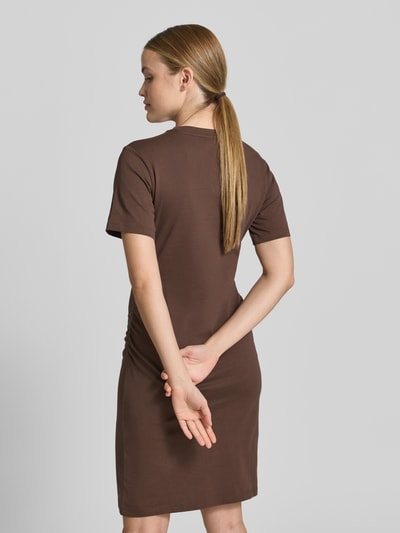 Frauenmodel trägt Knielanges T-Shirt-Kleid mit Rundhalsausschnitt von Jake*s Casual in Braun, reine Baumwolle, gerader Schnitt, Ganzkörperansicht Rückansicht.