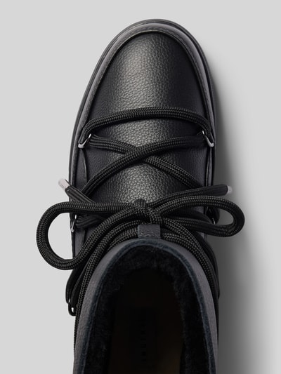 Produktfoto, Boots mit Logo-Detail von INUIKII, schwarze Farbe, abgerundete Passform, Schnür-Detail, leicht profilierte Sohle, strukturierte Oberfläche, Absatzhöhe 3 cm, Schafthöhe 15 cm, Schaftweite 15 cm, Nahaufnahme Obermaterial