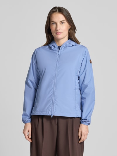 Kobiece modelka nosi Regular Fit Jacke mit Zweiwegereißverschluss Modell 'Stella' von SAVE THE DUCK, jasnoniebieska, gładka tekstura, kurtka damska, dwustronny zamek, kieszenie na zamek, długość tyłu w rozmiarze S: 60 cm, szerokość ramion w rozmiarze S: 42 cm, szerokość w biuście w rozmiarze S: 52 cm, długość rękawa w rozmiarze S: 64 cm, widok z przodu, ujęcie całej sylwetki.
