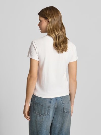 Frauenmodel trägt T-Shirt mit Rundhalsausschnitt und Logo-Stitching von Review, Baumwoll-Mix mit Stretch-Anteil, Körpernaher-Schnitt, Rückenlänge bei Größe S 53 cm, Ganzkörperansicht Rückansicht.