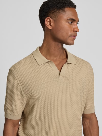 Mężczyznę model nosi Regular Fit Poloshirt aus reiner Baumwolle Modell 'NATALO' von BOSS, efekt: jednolity kolor, pika, krótki rękaw, kołnierzyk polo, dekolt w serek, prążkowane zakończenie, beżowy, widok z przodu, zbliżenie na górę ciała.
