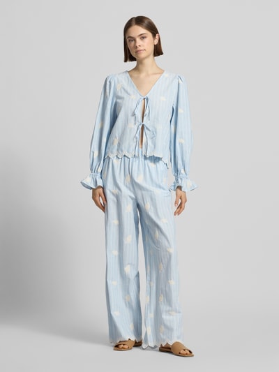 Frauenmodel trägt Hose mit Stitchings und elastischem Bund Modell 'Leni' von OH APRIL aus Reine Baumwolle, Relaxed-Fit, hellblau mit weißem Muster, Ganzkörperansicht von vorne.